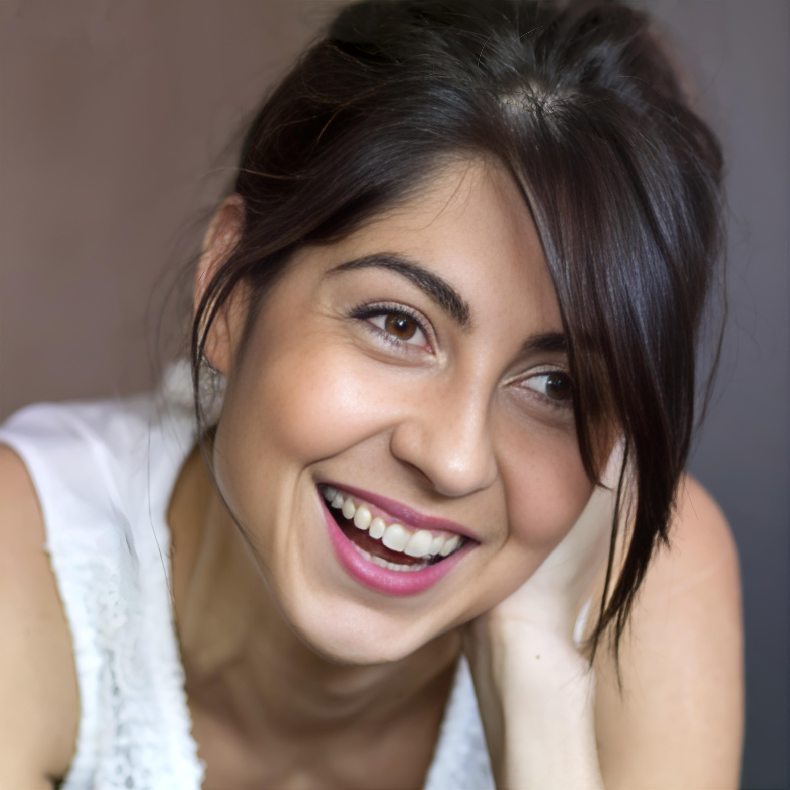 Adult female smiling, displaying metal braces on her teeth.